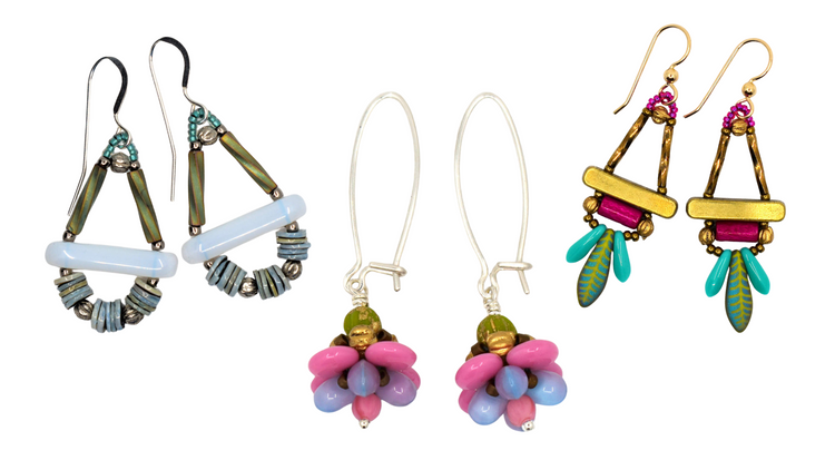 Three pairs of earrings laying on a white background. On the left are white and blue open teardrops shapes, in the middle are pink and purple flowers and on the right are gold triangle outlines with turquoise daggers underneath.