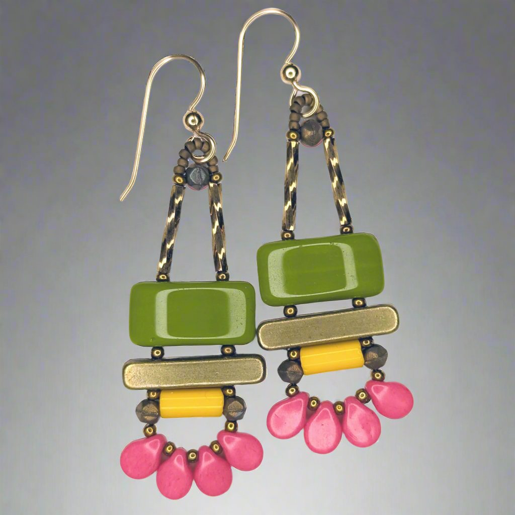 Long earrings against a soft gray background. Each earring has a wide avocado green rectangle stacked on top of a brass colored bar. Under the bar there is a light orange tube and a swag of four medium rose pink petal beads.