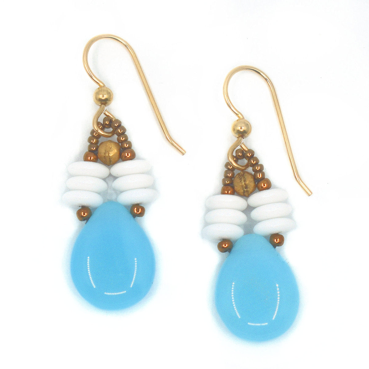 A pair of blue and white earrings laying on a white background. The earrings have a big pale blue teardrop suspended from two parallel stacks of white discs.