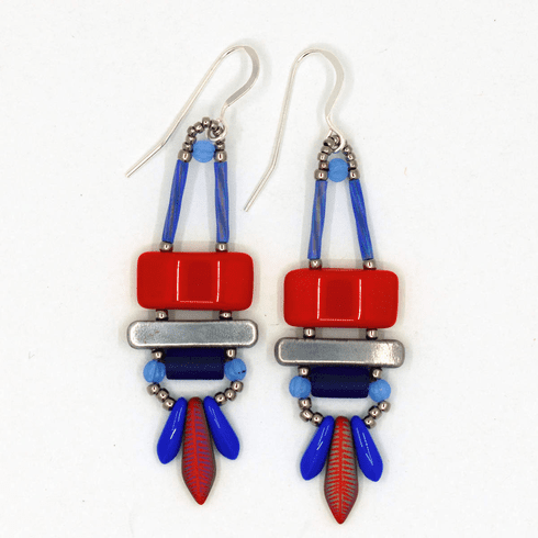 Bright red, blue and silver earrings on a white background. These earrings have a red rectangle on top of a silver bar, then a very dark blue tube with lighter blue rounds on either side. At the bottom there are two small medium blue daggers with a larger red dagger with a feather design on it.