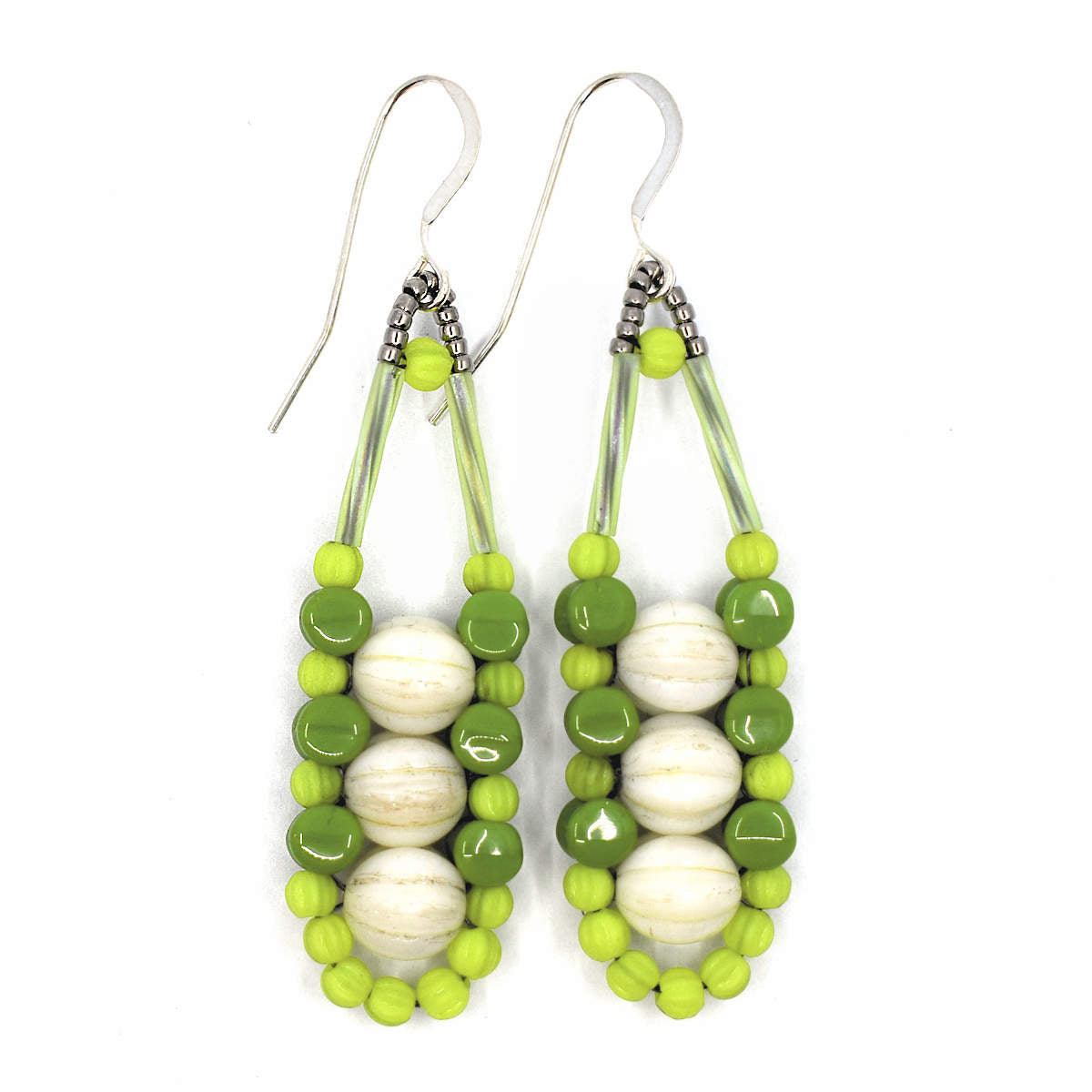 Cream and green earrings with silver accents and ear wires on a white background. These earrings have three cream rounds stacked vertically like peas and held in place by an outline of bright chartreuse and darker avocado green beads. 
