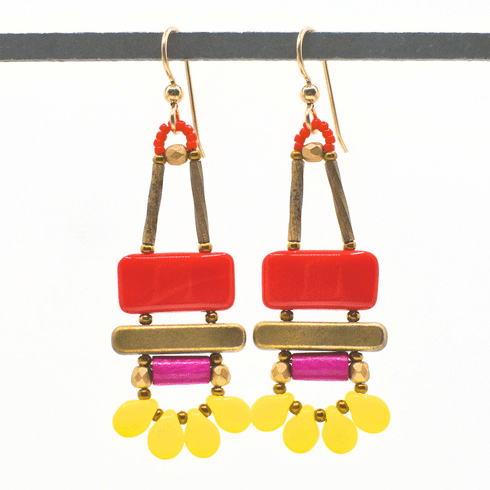 Bright red, magenta and yellow earrings with gold ear wires hang from a black bar, against a white background. These earrings have a warm red rectangle on top of a gold bar. Below the bar is a magenta tube and then a swag of four bright yellow petals separated by gold seed beads.