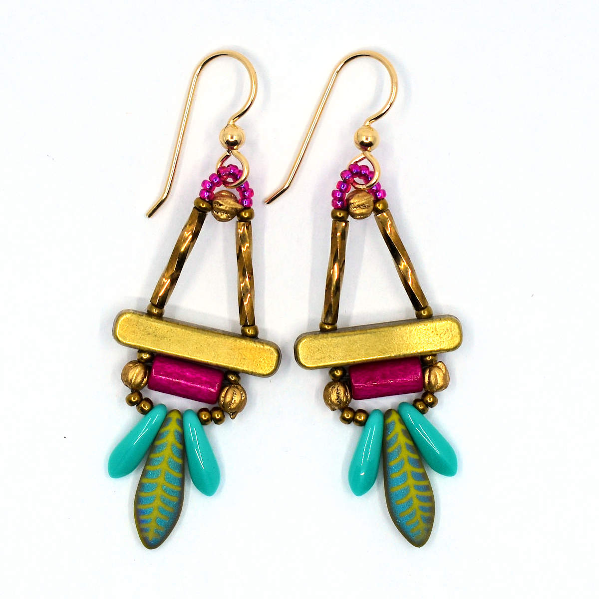 Turquoise, gold and magenta earrings on a white background. The earrings have two gold tubes that form the top of a triangle and a gold colored bar that forms the base. Below the bar is fat magenta tube with gold beads on either side. At the bottom is a green dagger etched with an iridescent feather pattern sandwiched between two smaller turquoise dagger beads.