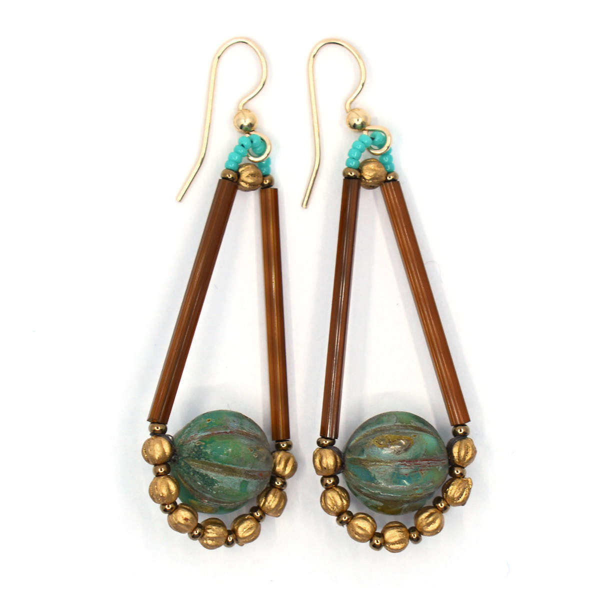 Long narrow earrings with a brown teardrop outline and an earthy varigated turquoise middle lay on a white background. The earrings have gold ear wires.