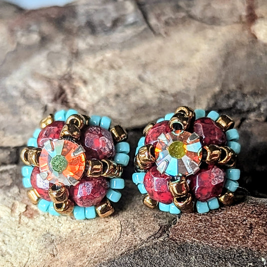 Four-lobed stud earrings made with burgundy and turquoise beads and a rhinestone center.
