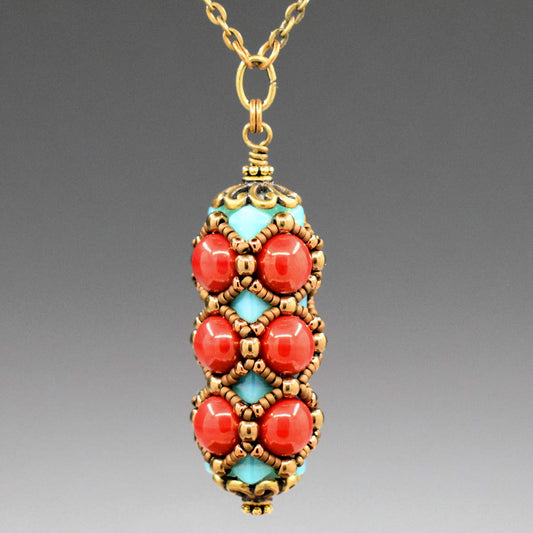 A columnar pendant formed from warm red round beads and lighter turquoise beads that do not show as prominently. The whole pendant is overlaid with a netting of matte and shiny gold seed beads.